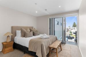a bedroom with a large bed and a window at Spacious apartment in Mount Maunganui in Mount Maunganui