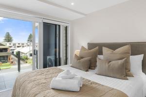 a bedroom with a large bed with a large window at Spacious apartment in Mount Maunganui in Mount Maunganui