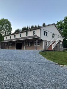 a large white building with a staircase on a driveway at Peaceful Mountain Farm in Honey Brook