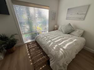 a bedroom with a bed and a large window at Lakeview Yamba Water Front Access 1 Small Pet Friendly in Yamba