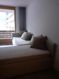 a couch sitting in a room with a window at Appartamento Valfurva 15 in Santa Caterina Valfurva