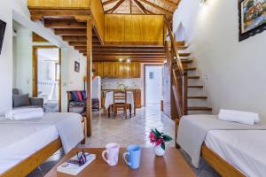 a living room with two beds and a staircase at Studios Galini in Skopelos Town