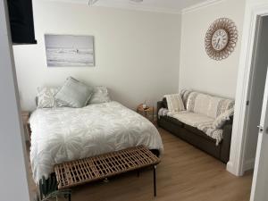 a bedroom with a bed and a couch at Lakeview Yamba Water Front Access 1 Small Pet Friendly in Yamba