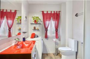 Un baño con un lavabo rojo y un inodoro. en Casa Rural Lunares y Salinera, en Albanchez de Úbeda 26 fotos más