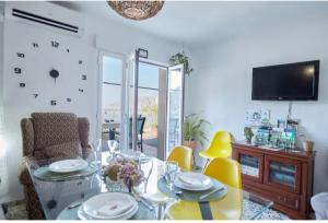 comedor con mesa de cristal y sillas amarillas en Casa Rural Lunares y Salinera, en Albanchez de Úbeda