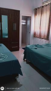 a bedroom with two beds and a door to a room at Ninho dos falcões in Nobres