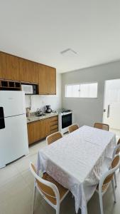 a kitchen with a white table and a white refrigerator at Salinas in Salinópolis