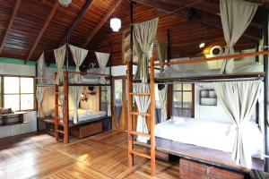 Dos literas en una habitación con techos de madera. en Salty Enthusiasts Share House & Villas, en Santa Teresa Beach