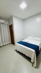 a bedroom with a large bed with a blue blanket at Salinas in Salinópolis +25 photos