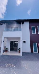 a white house with two potted plants in front of it at Salinas in Salinópolis