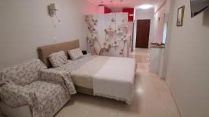 a bedroom with a bed and a chair at Modern Studio by the sea in Loutra Edipsou
