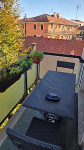 a table and chair on a balcony with plants at Rocca view central flat in Arona