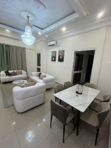 a living room with a white table and chairs at Essentiel immo in Brazzaville