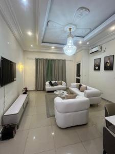 a living room with two white couches and a television at Essentiel immo in Brazzaville