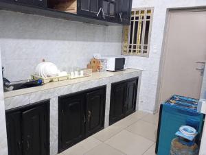 a kitchen with black cabinets and a counter top at Essentiel immo in Brazzaville +10 photos