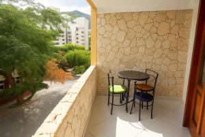 a small balcony with a table and two stools at El Velero Apartamentos By DANP in Santa Marta