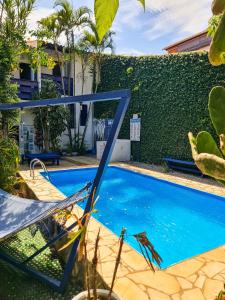 a blue swimming pool with a chair next to a building at Pousada Bicho do Mar in Arraial do Cabo