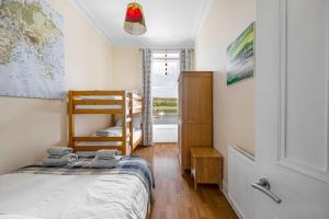 a small bedroom with a bunk bed and a window at Above The Bay in Port Bannatyne