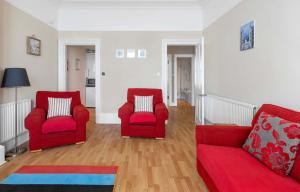 two red chairs and a red couch in a living room at Above The Bay in Port Bannatyne +4 photos