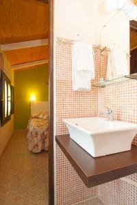 baño con lavabo y habitación con cama en Un Rincón en la Mancha, en Villar de Cañas
