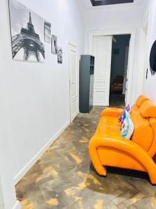 een oranje stoel in een kamer met de Eiffeltoren bij CityGate Kraków in Krakau