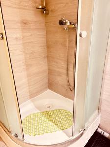 een douche met een glazen deur in een badkamer bij CityGate Kraków in Krakau