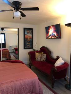 a bedroom with a bed and a couch and a fan at Cozy private room in Princeton