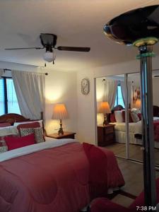 Cozy private room and kitchen في Princeton: غرفة نوم بسرير احمر ومرآة