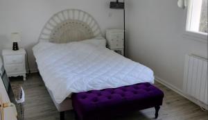 een bed met een paarse bank in een slaapkamer bij Appartement avec parking privé in Aytré