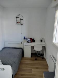 een slaapkamer met een bed en een bureau met een basketbalring bij Appartement avec parking privé in Aytré