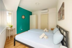 Un dormitorio con una cama con una pared verde. en Cozy Seaview Apartment Sliema S6, en Sliema