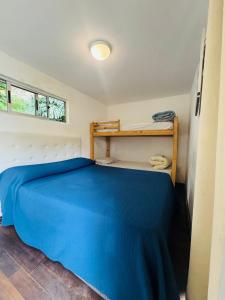 een slaapkamer met een bed met een blauwe sprei bij Posada Punta del Este in Punta del Este