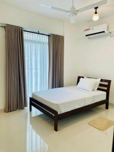 a bedroom with a bed and a window at Bright 3-Bed Flat with Balcony with Great Value in Sri Jayewardenepura Kotte