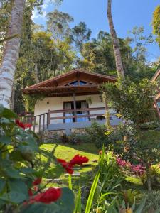 a house in the middle of a garden at Chalé Au Clair de Lune Terê in Teresópolis