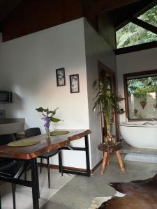 a room with a table and a bath tub at Chalé Au Clair de Lune Terê in Teresópolis