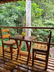 a wooden table and two chairs on a deck at Pousada Bella Ana in Visconde De Maua +158 photos