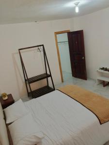 ein Schlafzimmer mit einem weißen Bett und einem Spiegel in der Unterkunft Amplio departamento para 10 personas in Cuenca