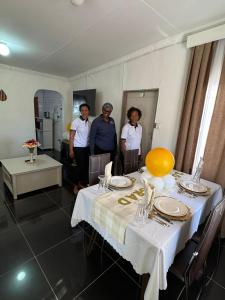 a group of people standing around a dining room table at BJ&T Vacation Homes in Kasane