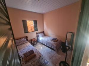 a small bedroom with a bed and a mirror at MAEVE Hostel in Goiás
