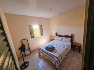 a small bedroom with a bed and a window at MAEVE Hostel in Goiás