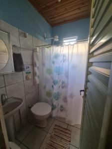 a bathroom with a shower curtain and a toilet at MAEVE Hostel in Goiás +4 photos