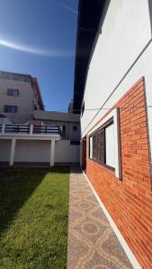 Seitenansicht eines Gebäudes mit einer Backsteinmauer in der Unterkunft Prudêncio Casas de Temporada in Torres