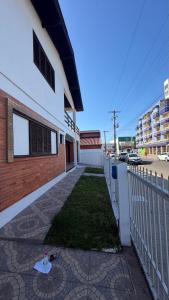 ein Gebäude mit einem Zaun neben einem Hof in der Unterkunft Prudêncio Casas de Temporada in Torres