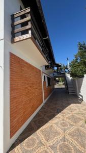 ein Gebäude mit einer roten Backsteinmauer und einer Treppe in der Unterkunft Prudêncio Casas de Temporada in Torres + 25 Fotos