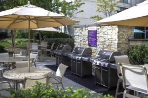 Metro-Accessible Spacious Apartment Near DC في Addison Heights: فناء خارجي مع طاولات وكراسي ومظلات +20 صورة