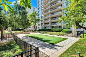 Metro-Accessible Spacious Apartment Near DC في Addison Heights: عمارة سكنية مع ملعب تنس في حديقة