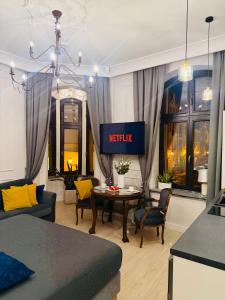 a living room with a bed and a table at Apartamenty PREMIUM Rynek 21 in Toruń