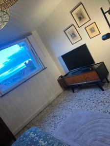 a bedroom with a flat screen tv and a window at Chez Léopold in Verviers