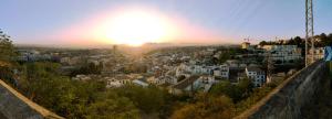 a view of a city with the sun setting at Duplex-Loft Albaicín Granada in Granada
