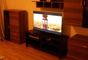 a flat screen tv sitting on a wooden dresser at Fortl's Apartment in Herzogenaurach +7 photos